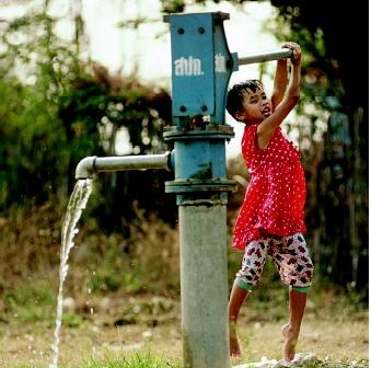 Modern lift pumps intended for village or community wells often are specially designed to support heavy, sustained use. This girl pumps water in Phai Sali, Thailand.